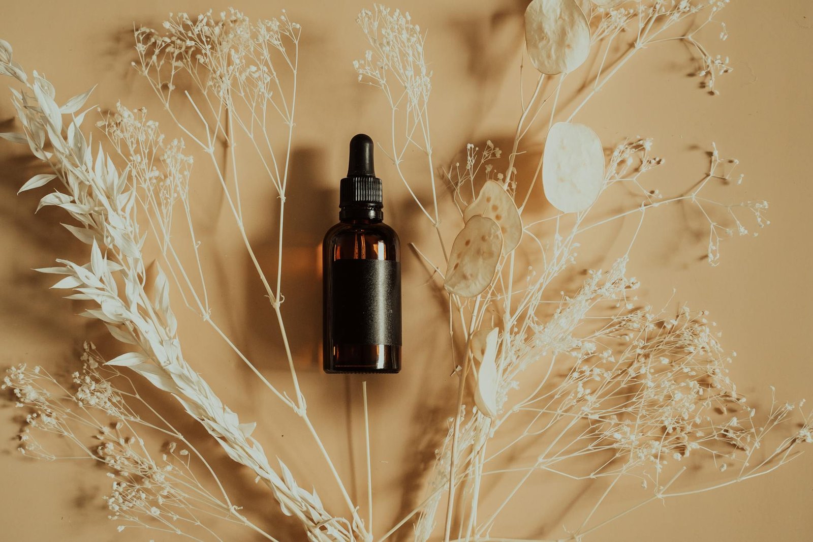 brown bottle on top of dried plants